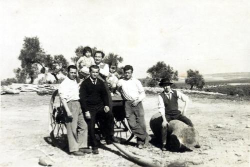 Aparecen en la foto junto al carro de Santa Isabel, Pepe Pérez, a la derecha, con camisa blanca y su hermano Alfonso con corbata. Las niñas son Inés, hija de Pepe, y Soledad, hija de Ángela. El resto de personajes, trabajadores habituales de la finca, no han podido ser identificados. Fuente: Enrique Pérez Jiménez.