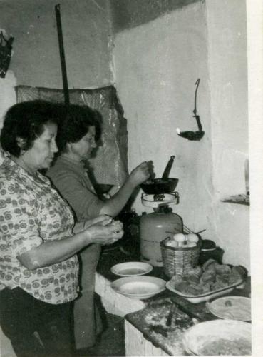 Rafaela Pérez Castro, en primer plano, junto a la casera, haciendo roscos de aceite en la cocina que había detrás de la gran chimenea del salón de abajo. Fuente: Ricardo García Pérez.